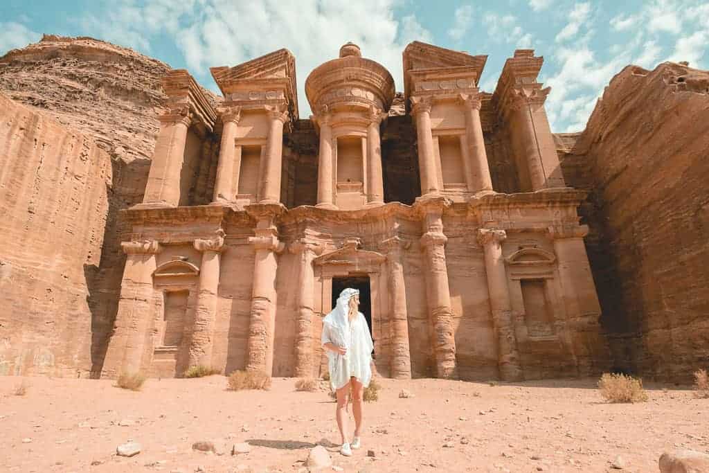 girl in white standing in front of the montastery in petra